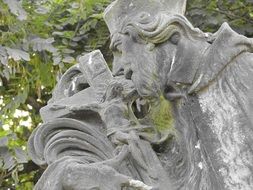 saint with Crucifixion, aged stone statue, detail