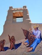 woodcarver, painting on wall of house, usa, new mexico, taos