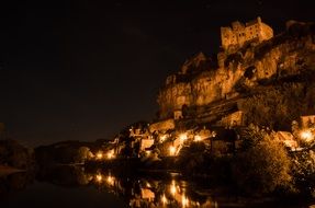 village on slope at night, france, dordogne, beynac