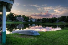 boat upside down on lake coast at summer evening