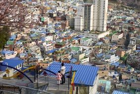 asian man with child girl on roof looking at town, korea, busan