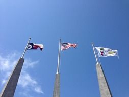 texas and american flags at blue sky, usa