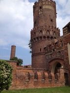 Beautiful old castle with a tower among colorful plants in the old town