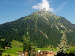 cloud at top of green mountain, scenic summer landscape, switzerland