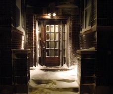 snow coverd steps at vintage entrance door at night