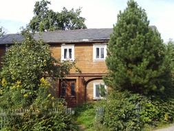 big old house behind green trees