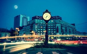 street clock on piata romana at full moon night in romania, Bucharest