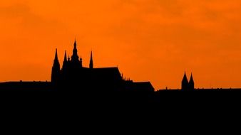 dark silhouette of castle and cachedral at orange sky, czech, prague