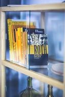 yellow books on glass bookstand