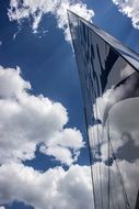 clouds are reflected on the facade of a skyscraper