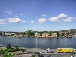 vehicles on road in view of town at river, sweden, gothenburg