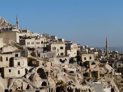 minarets on mountain side among tuff stone dwellings, turkey, uchisar