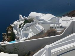 white apartment terrace on cliff at blue sea, greece, santorini, caldera