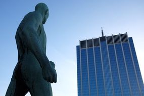 Statue of man looking at building