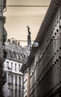street lamp on wire between old buildings, hungary, budapest