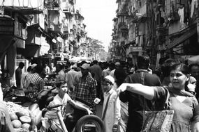 black and white photo of a crowd of people on the street, mumbai, india