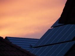 sunset over solar panels on a roof