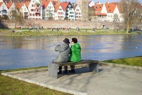 People rest on bench river bank view