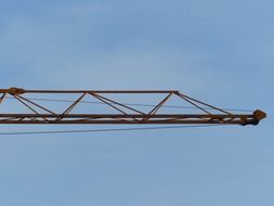 Boom of a construction crane against the background of a clear sky