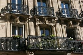 ornate balconies with wrough iron fence on facade of historical building, france, paris