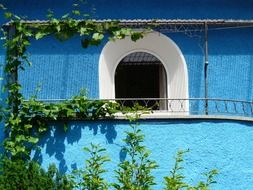 window with a balcony on a building with blue walls