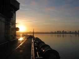 sunrise above distant city, view from navy ship, usa, california, san diego