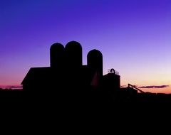 silhouette of a rural barn against a purple sky