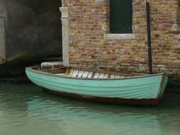 green boat by the water house