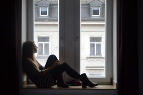 girl is sitting on the windowsill