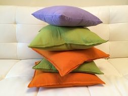 stack of colorful pillows on sofa