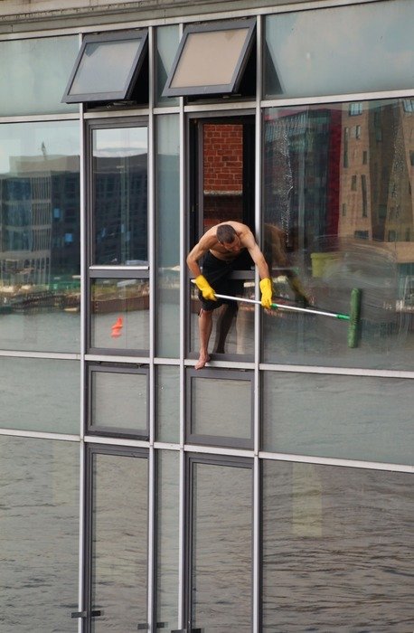 window cleaner, man with mop on glass facade