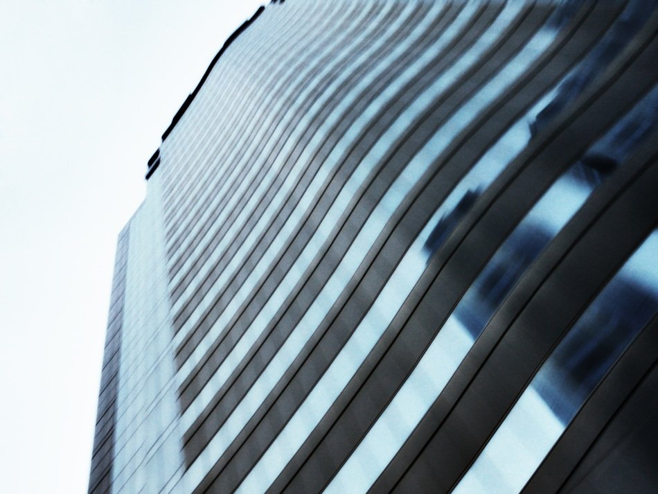 low angle diagonal view of striped modern facade at sky