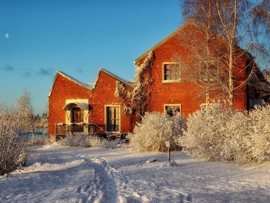 red brick house in snowy winter landscape, finland