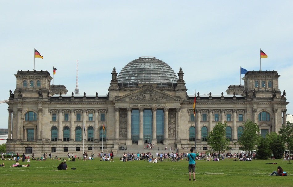 people resting on lawn at bundestag building, germany, berlin