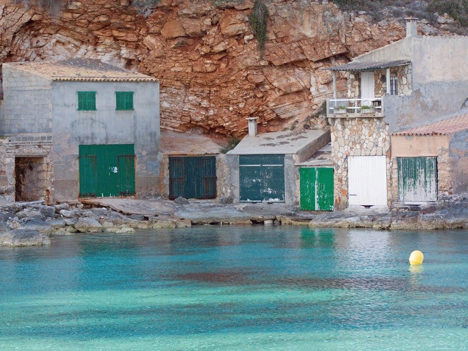 buildings with boat garages on cliff at sea, spain, mallorca