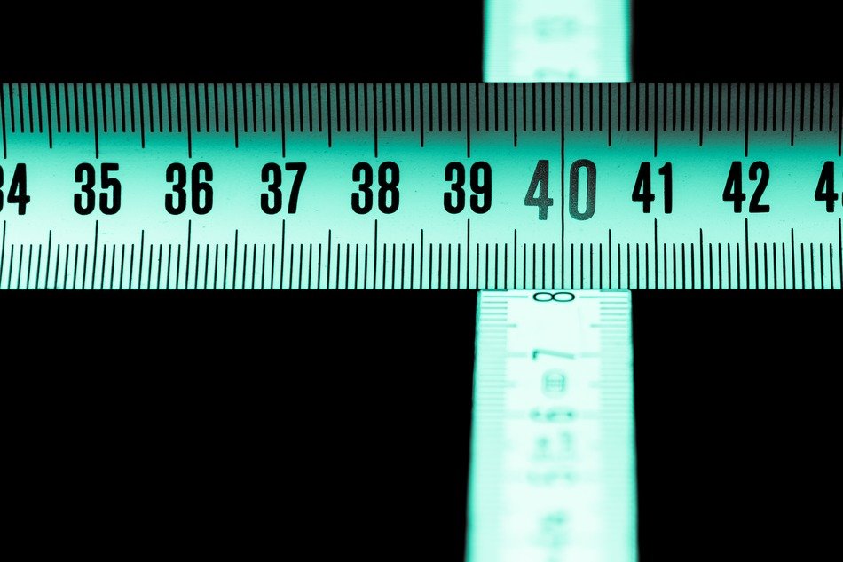 crossing green measuring tapes at dark background