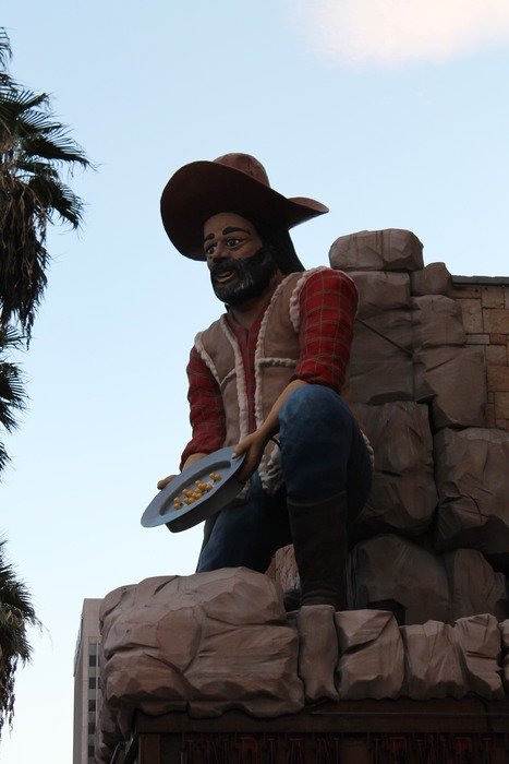 cowboy with gold on plate, figure on wall at sky, usa, nevada, las vegas