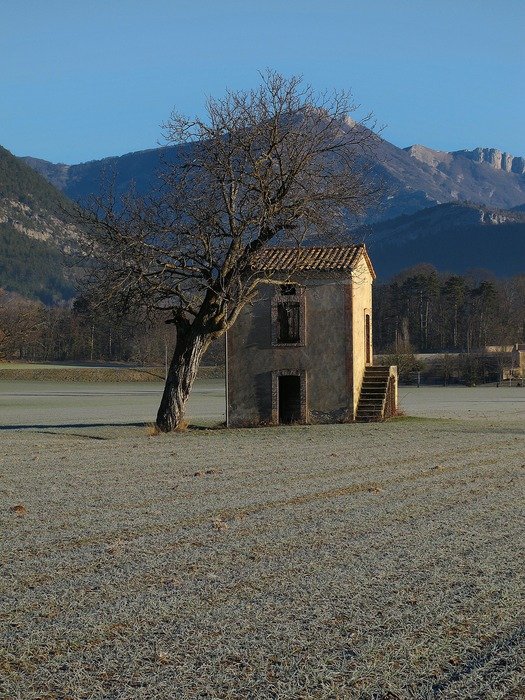 old stone building on field at mountains, france, diois