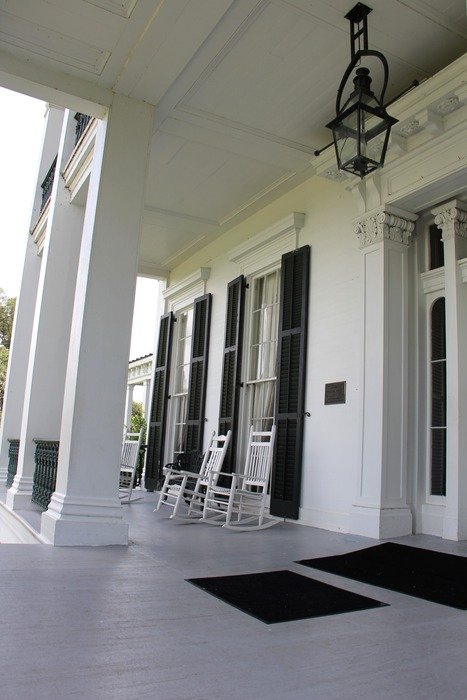 white columns porch entrance front rockers chairs