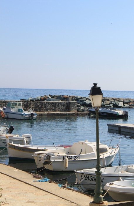 boats at pier with vintage lamp post, france, corsica