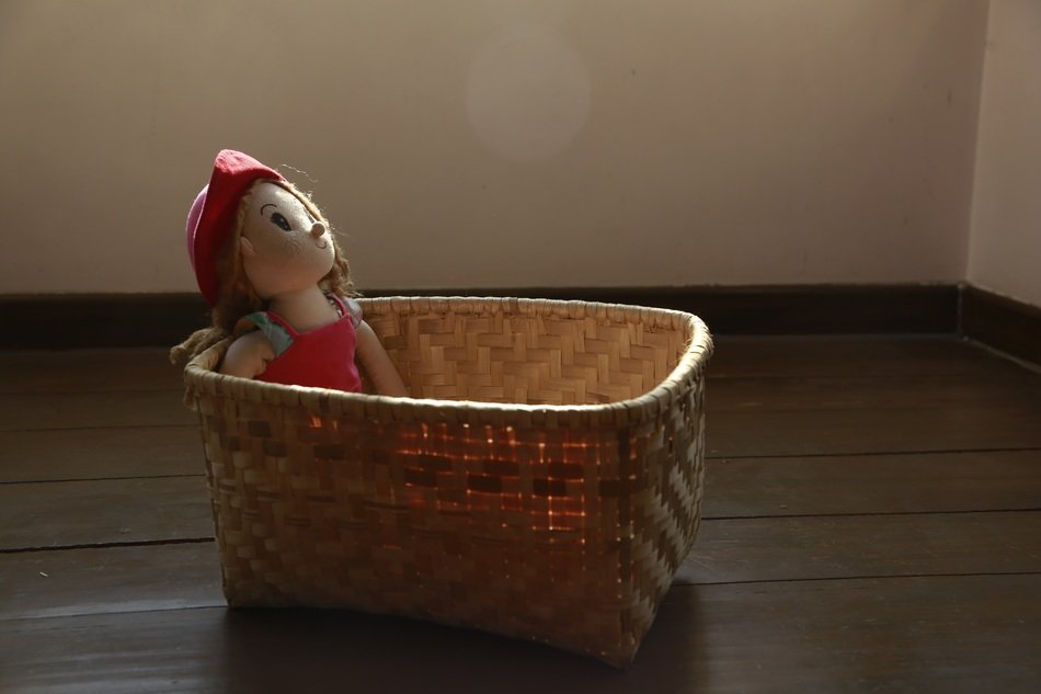 basket with doll inside on the floor