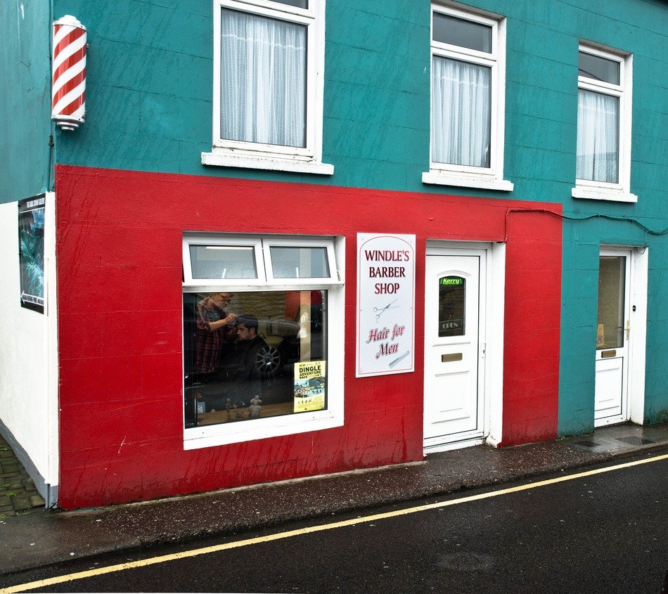 red barber shop display on green facade, uk, ireland