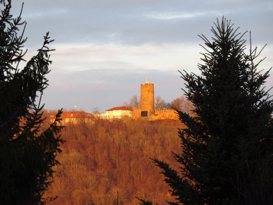 distant medieval castle behind forest at winter, germany, staufeneck