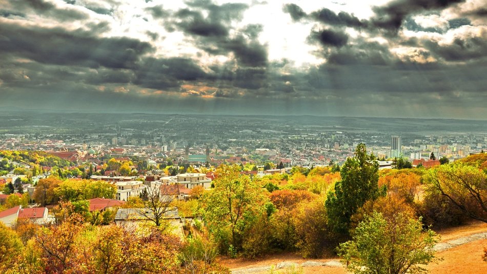 sunbeams bursting through clouds above city at autumn, hungary