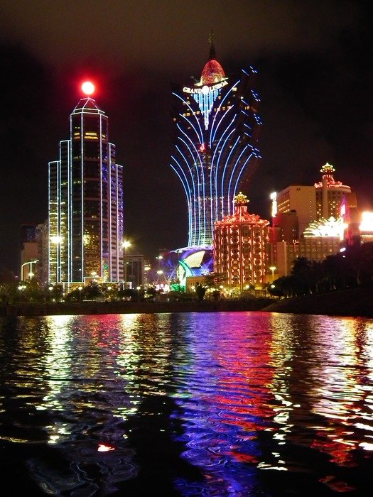colorful bright illuminated casinos on waterfront at night, china, macau