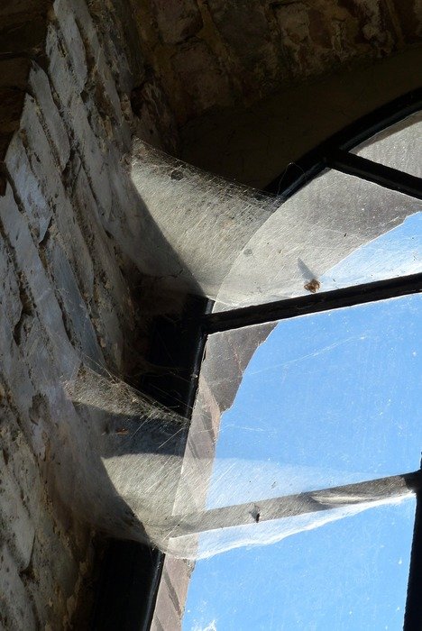 old brick factory window with spider webs