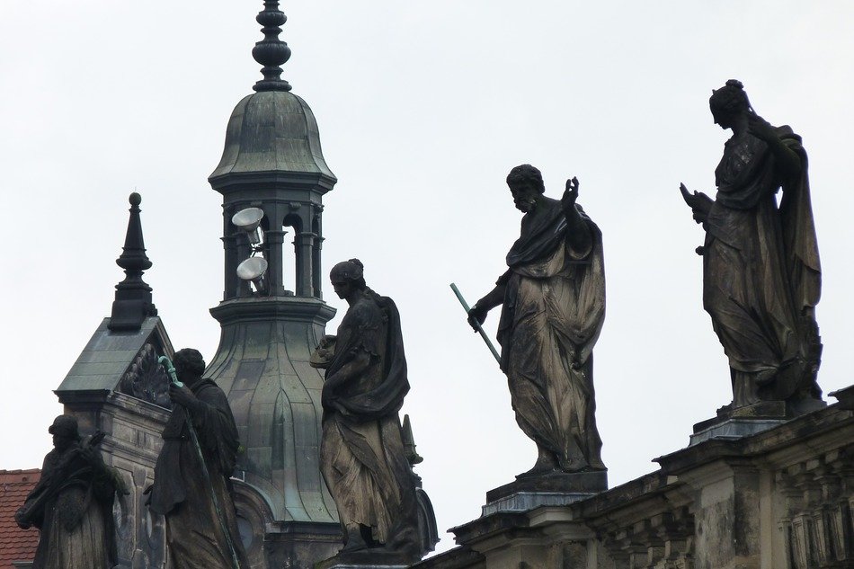 aged stone sculptures on roof at steeple, germany, dresden