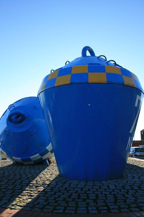 two blue buoys, monument on beach
