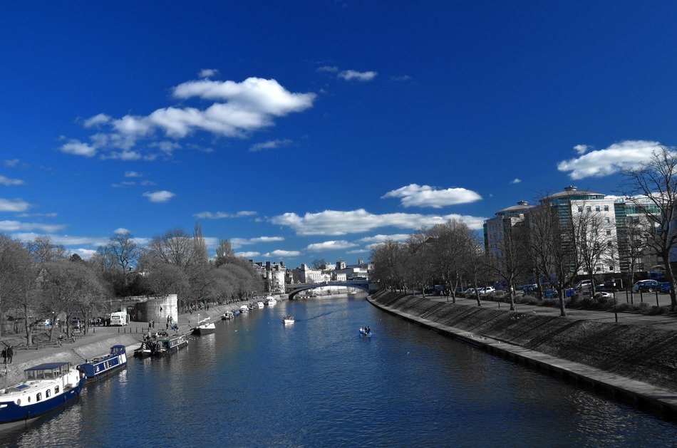 blue sky above canal in grey city, postproduction