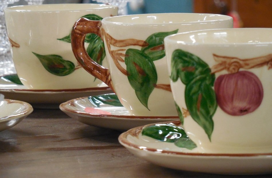 decorative painted ceramic teacups in row on table